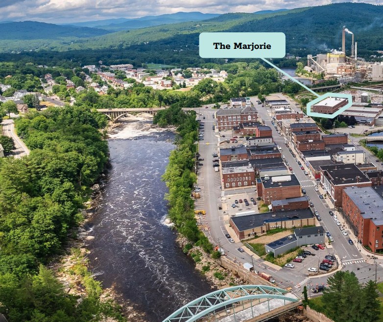 Aerial view of downtown Rumford, Maine along the river, with the building planned for The Marjorie marked
